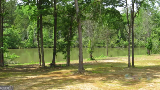 a large kitchen with stainless steel appliances granite countertop a stove top oven a sink dishwasher and white cabinets with wooden floor