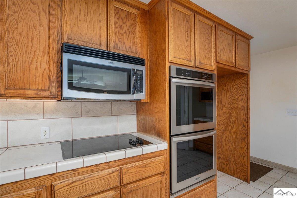19950 Red Bank Road Red Bluff, CA 96080 - Photo 10 of 69 a kitchen with granite countertop white cabinets and stainless steel appliances