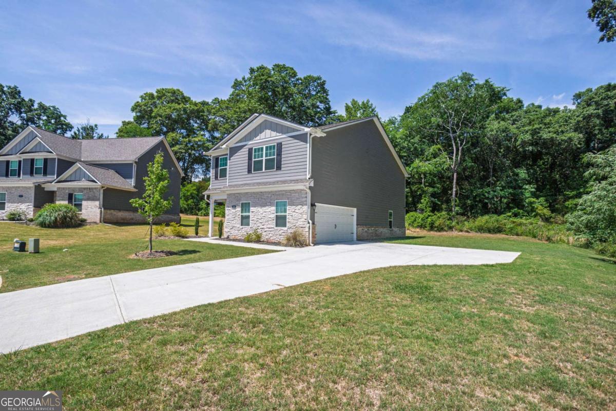 653 Meadows Farm Way Monroe, GA 30655 - Photo 2 of 34 a front view of a house with a yard and garage
