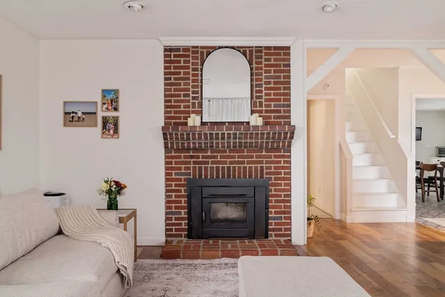 a view of a livingroom with wooden floor and a fireplace