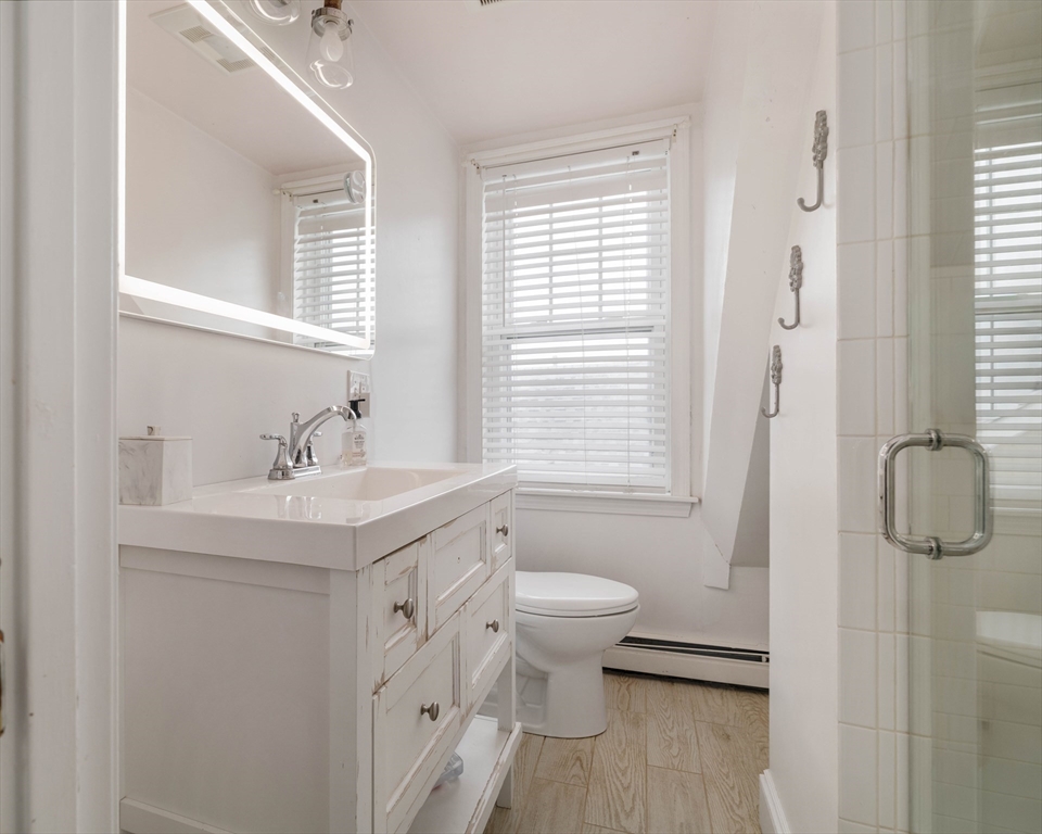 129 The Strand Winthrop, MA 02152 - Photo 27 of 42 a bathroom with a sink a toilet and shower