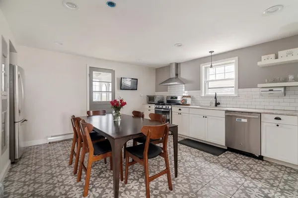 a kitchen with stainless steel appliances white cabinets and wooden floor