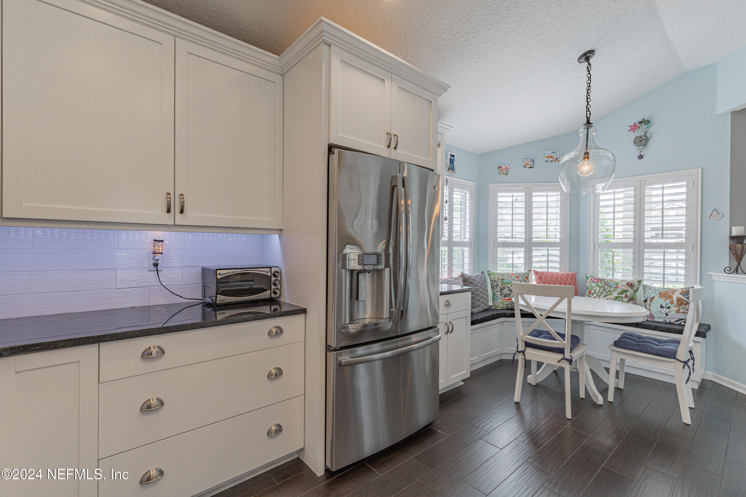 1830 Copper Stone Drive, Unit D Fleming Island, FL 32003 - Photo 11 of 65 a kitchen with stainless steel appliances granite countertop a refrigerator a sink dishwasher a stove and white cabinets with wooden floor