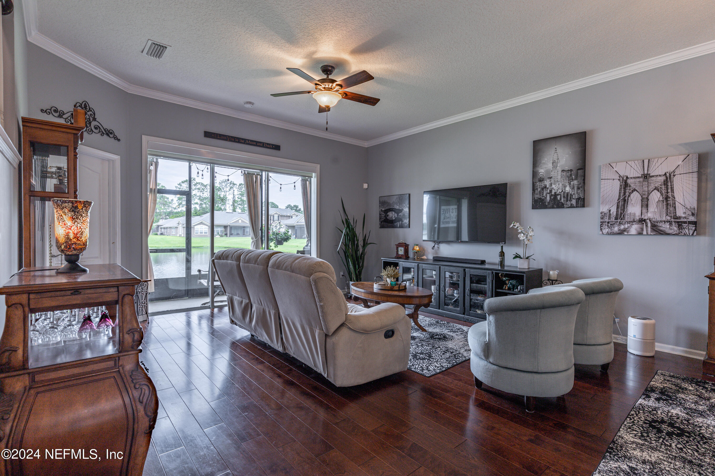 1830 Copper Stone Drive, Unit D Fleming Island, FL 32003 - Photo 16 of 65 a living room with furniture a fireplace and a flat screen tv