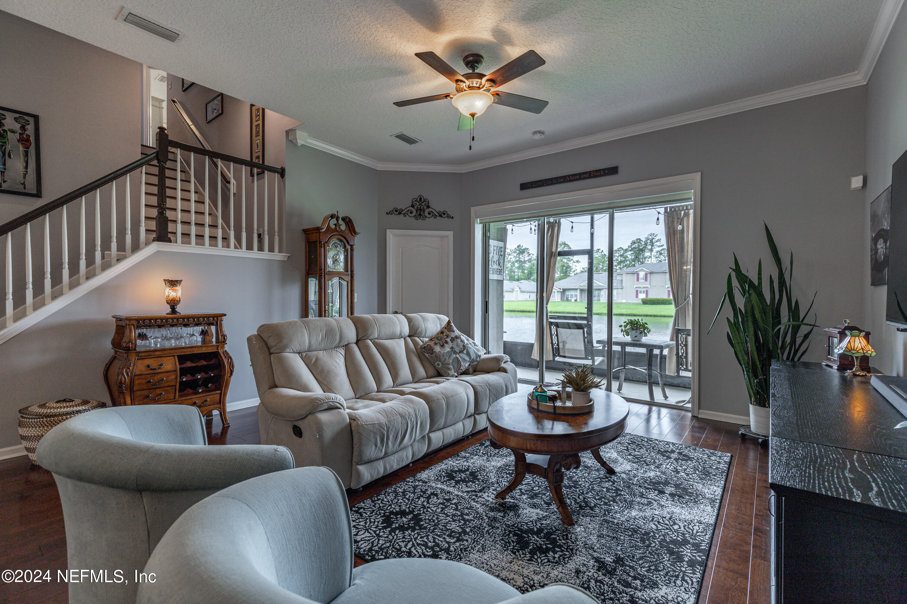 1830 Copper Stone Drive, Unit D Fleming Island, FL 32003 - Photo 17 of 65 a living room with furniture a chandelier and a large window