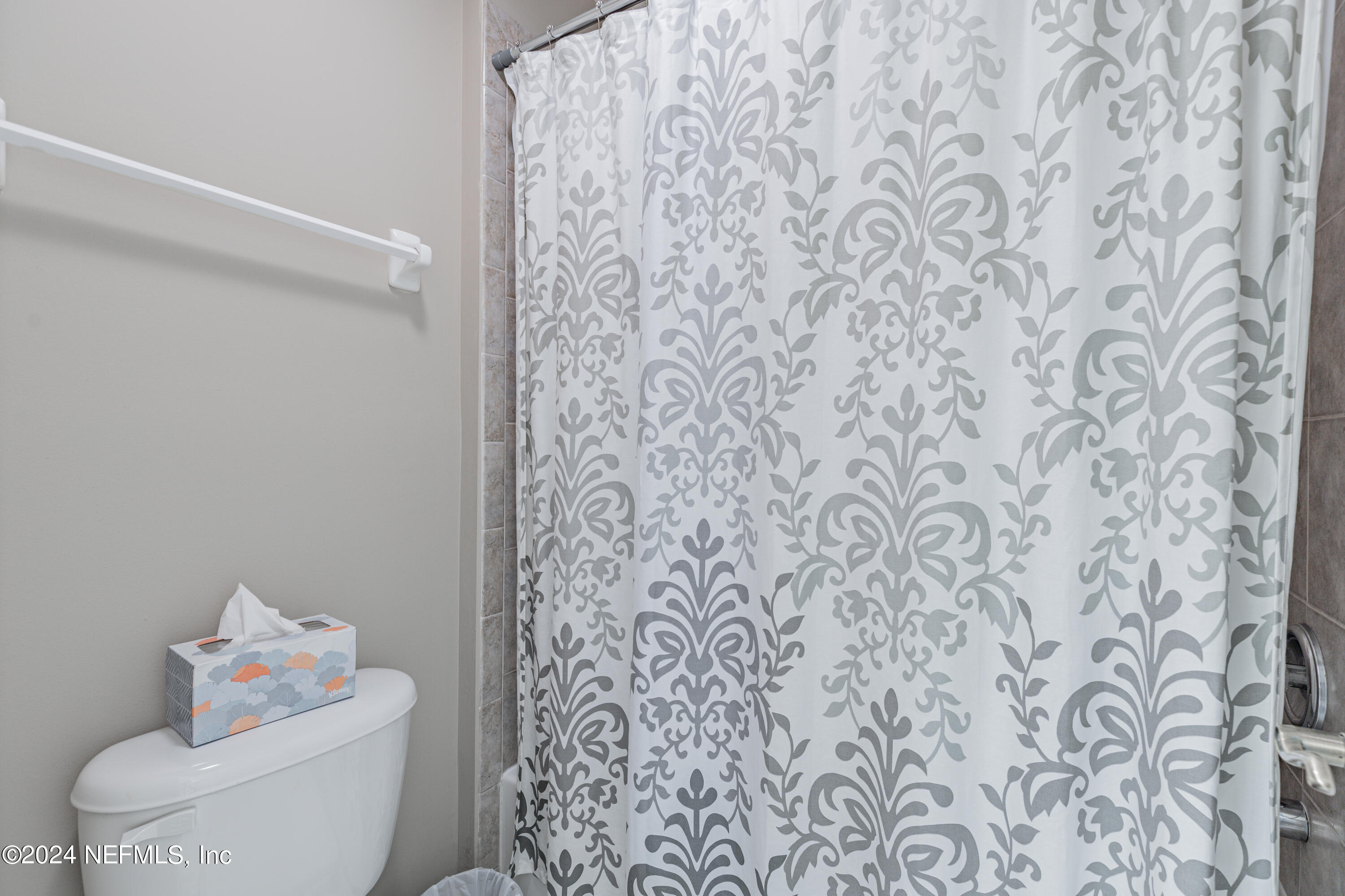 1830 Copper Stone Drive, Unit D Fleming Island, FL 32003 - Photo 27 of 65 a bathroom with a toilet and shower curtain