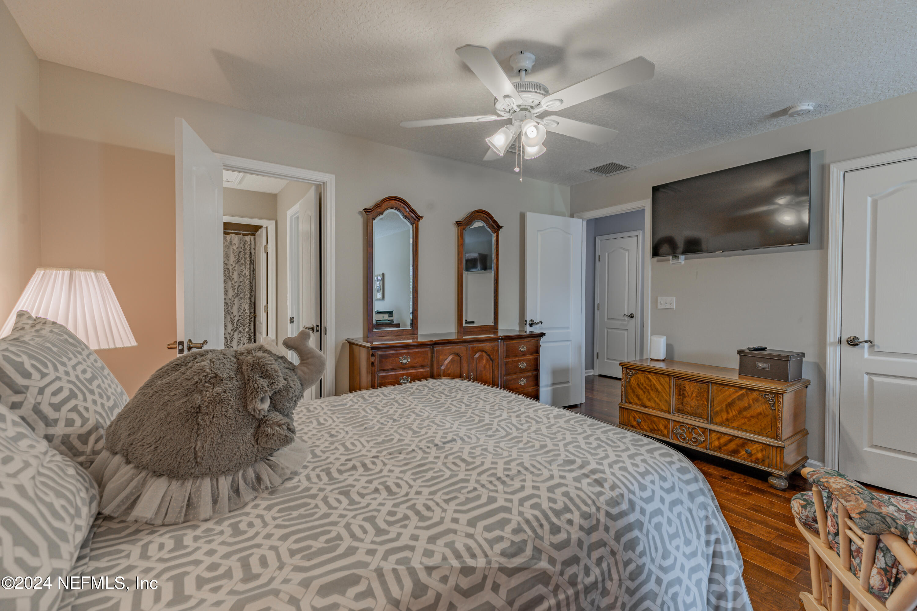 1830 Copper Stone Drive, Unit D Fleming Island, FL 32003 - Photo 29 of 65 a bedroom with a large bed and a chandelier