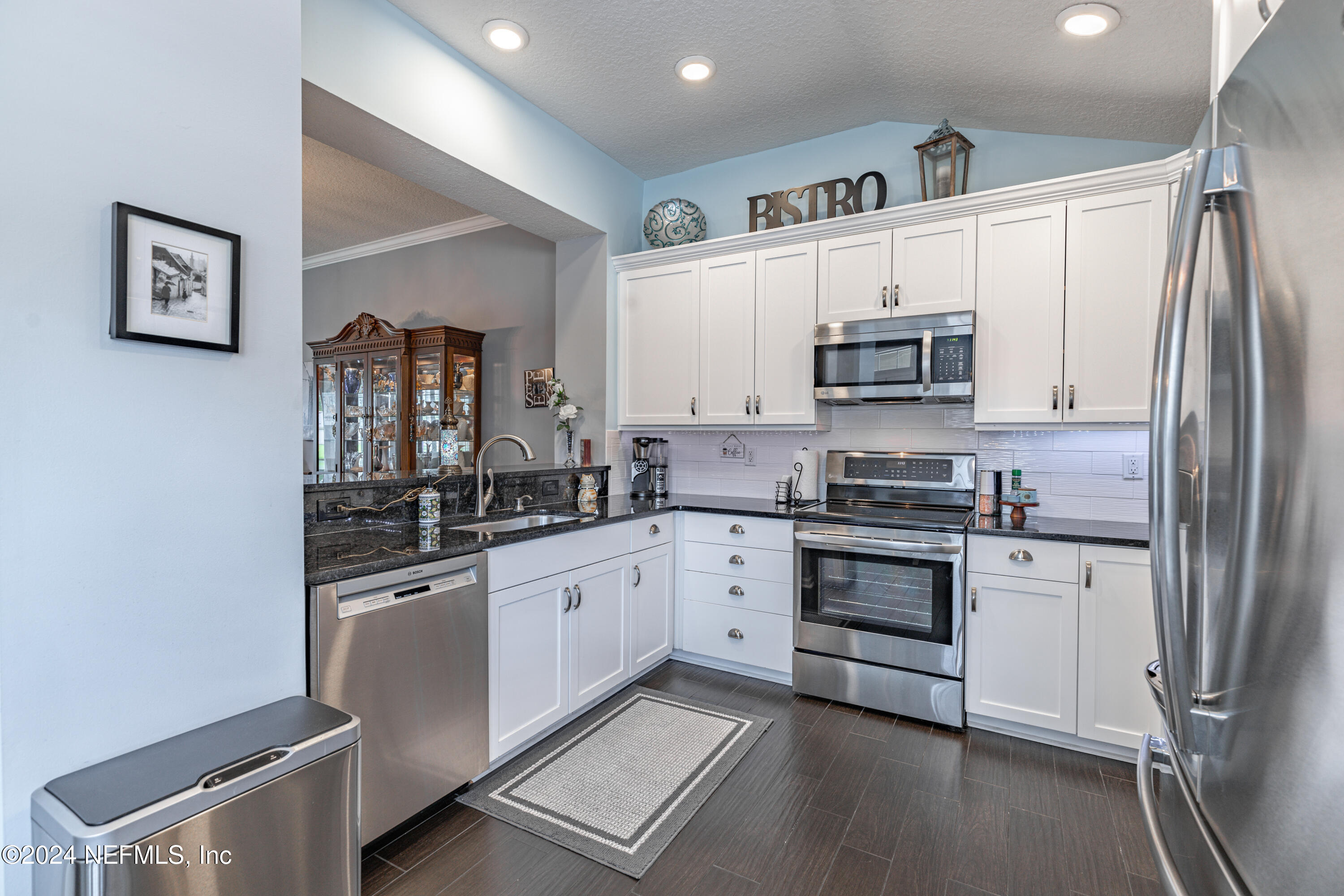 1830 Copper Stone Drive, Unit D Fleming Island, FL 32003 - Photo 9 of 65 a kitchen with stainless steel appliances a refrigerator sink and microwave