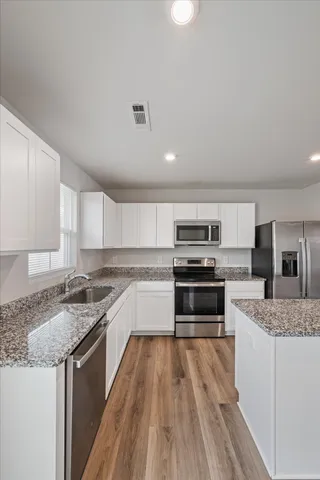 a kitchen with a stove a sink and a microwave