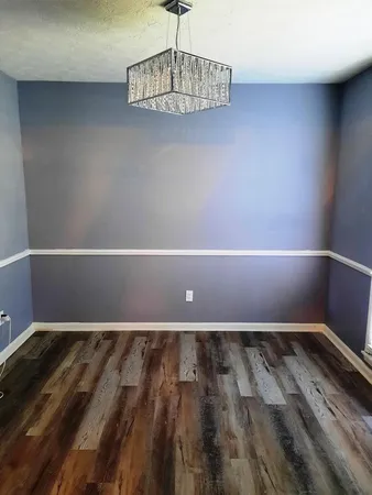 a view of a room with wooden floor and window