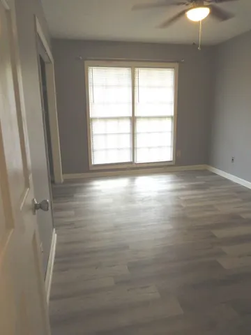 en empty room with window and hardwood floor