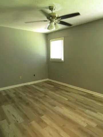 an empty room with a window and a fan
