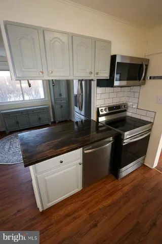 a kitchen with a refrigerator cabinets and wooden floor
