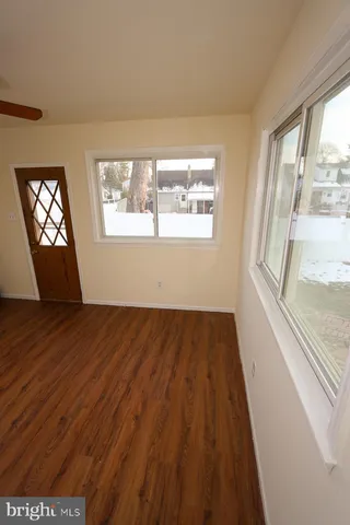 a view of empty room with wooden floor and ceiling fan