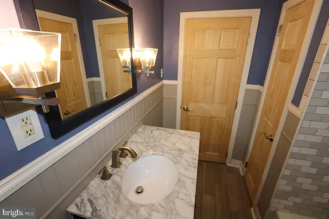 a bathroom with a granite countertop sink a toilet and bathtub