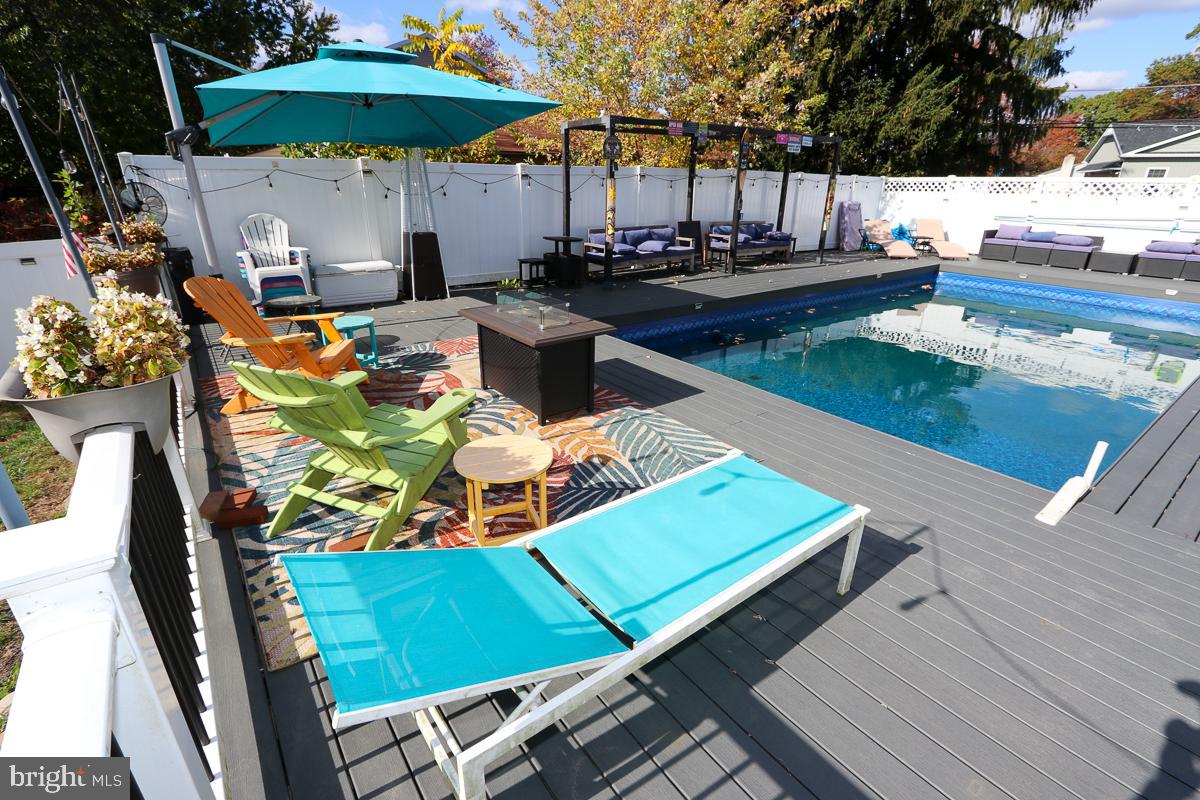 201 Castello Avenue Hatboro, PA 19040 - Photo 48 of 64 a view of a patio with table and chairs under an umbrella with wooden floor