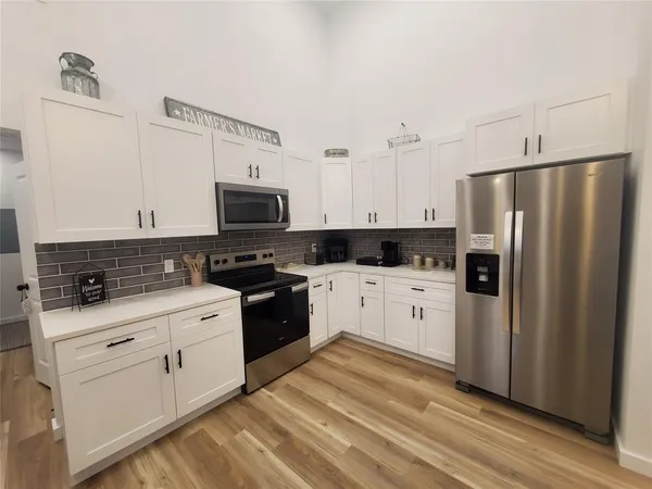 a kitchen with sink a refrigerator and chairs