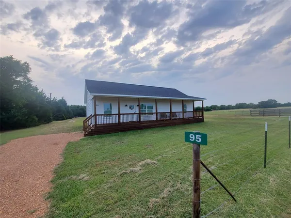 a view of a lake with a big yard and large trees