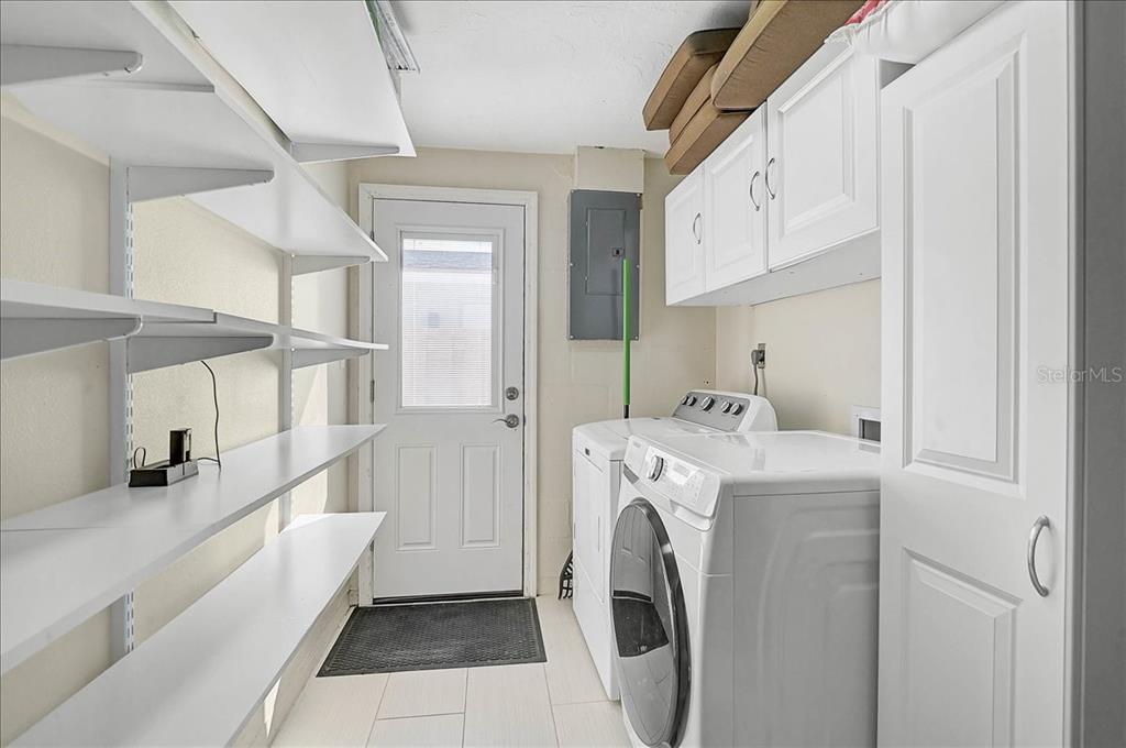 4514 South Lockwood Ridge Road Sarasota, FL 34231 - Photo 12 of 35 a view of washer and dryer with kitchen in the background