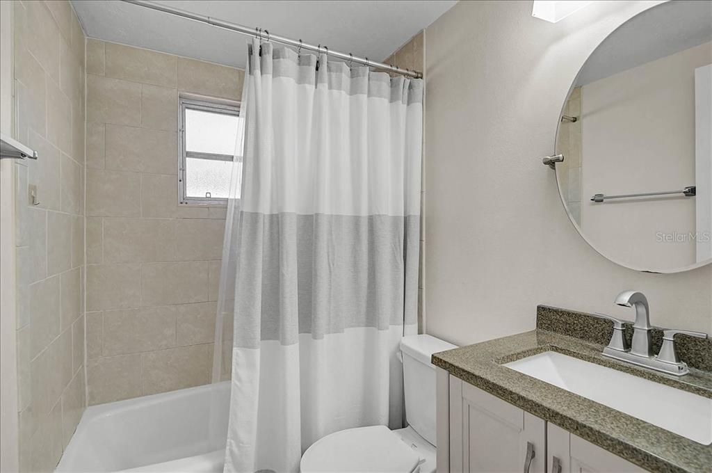 4514 South Lockwood Ridge Road Sarasota, FL 34231 - Photo 14 of 35 a bathroom with a granite countertop sink toilet and shower