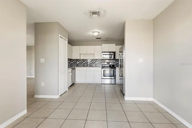 a kitchen with stainless steel appliances a refrigerator and a stove top oven