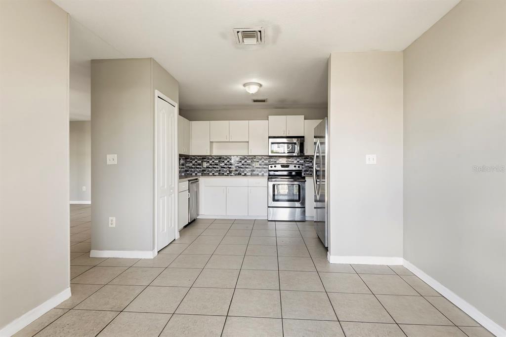 15313 Southwest 138th Terrace Miami, FL 33196 - Photo 13 of 44 a kitchen with stainless steel appliances a refrigerator and a stove top oven