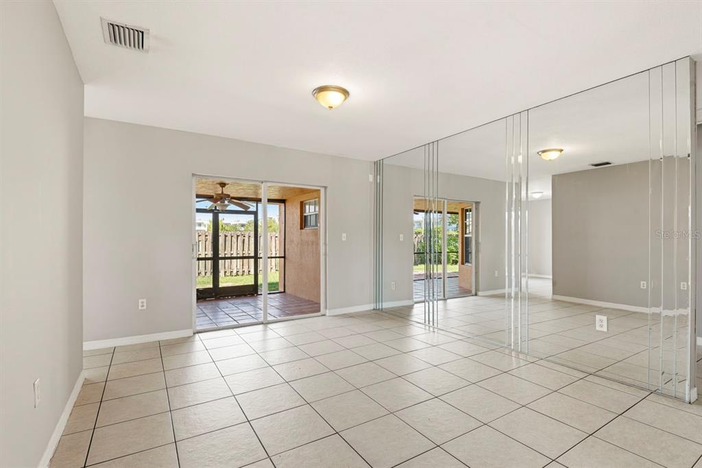 15313 Southwest 138th Terrace Miami, FL 33196 - Photo 17 of 44 a view of an empty room with window and chandelier fan