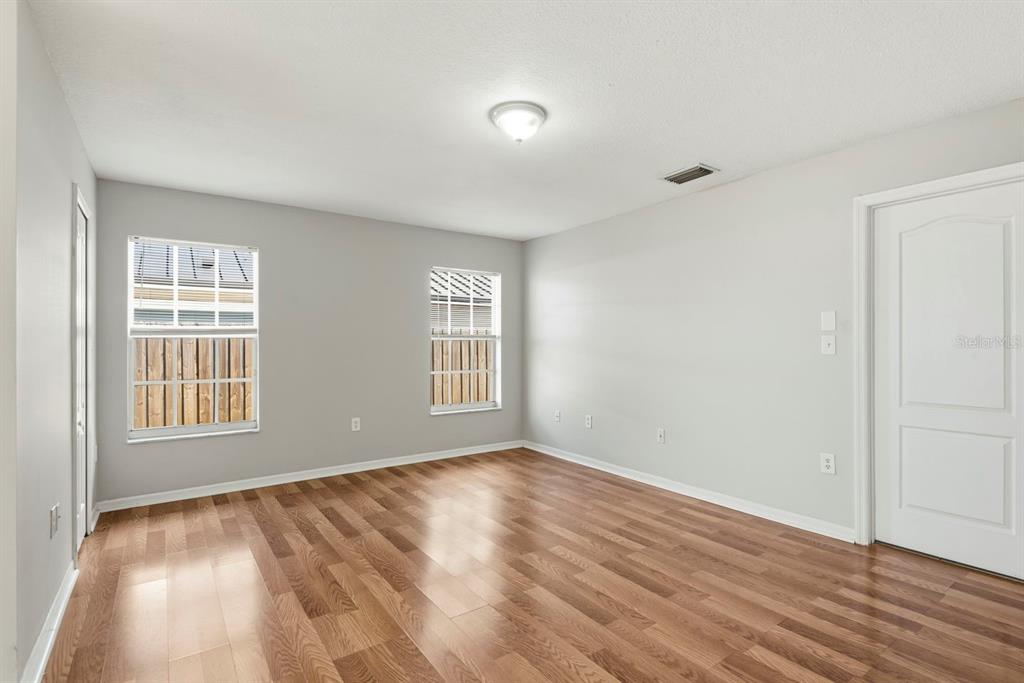 15313 Southwest 138th Terrace Miami, FL 33196 - Photo 21 of 44 an empty room with wooden floor and windows