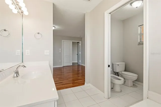 a bathroom with a toilet sink and mirror