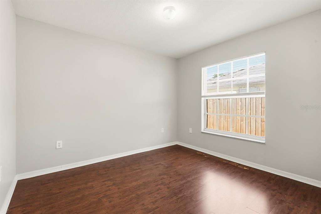 15313 Southwest 138th Terrace Miami, FL 33196 - Photo 30 of 44 an empty room with wooden floor and windows