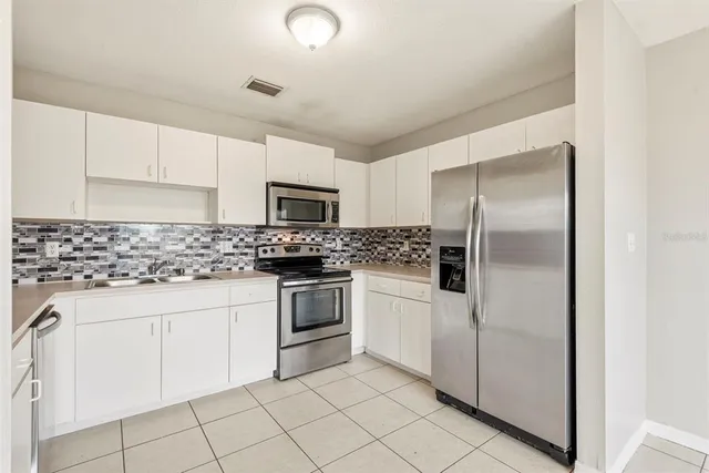 a kitchen with white cabinets stainless steel appliances and sink