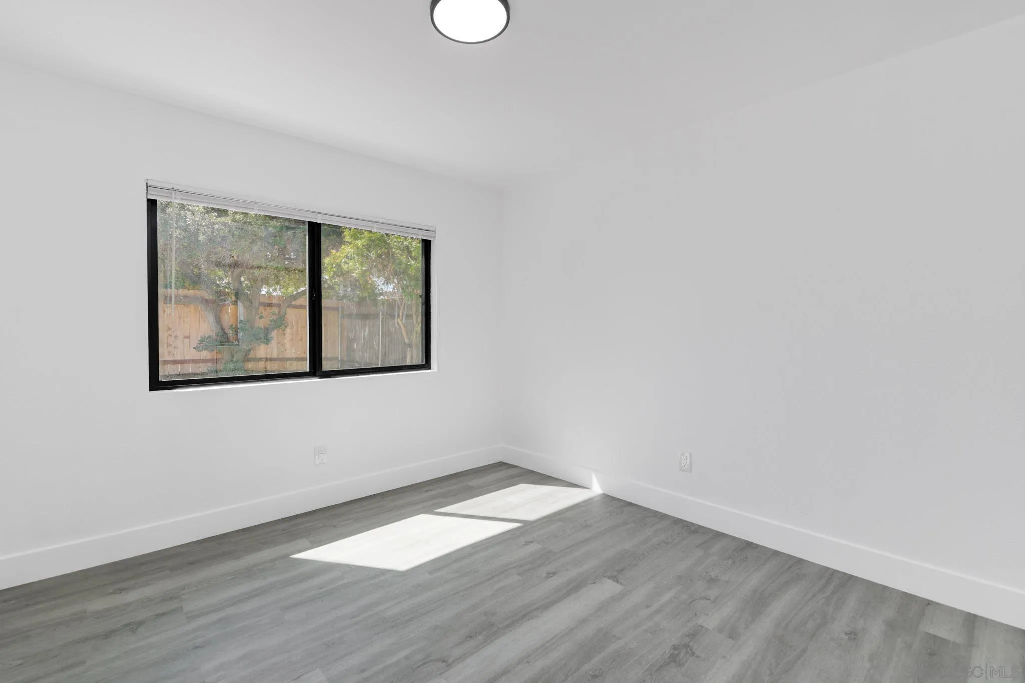 9125 Akard Street Spring Valley, CA 91977 - Photo 14 of 25 an empty room with wooden floor and windows