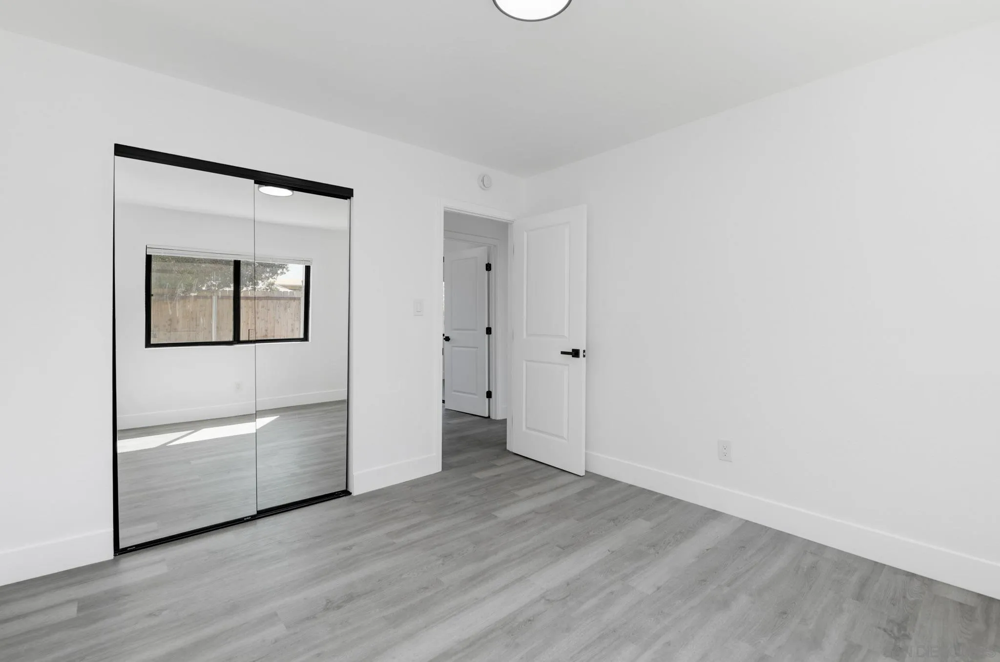 9125 Akard Street Spring Valley, CA 91977 - Photo 17 of 25 an empty room with wooden floor and mirror