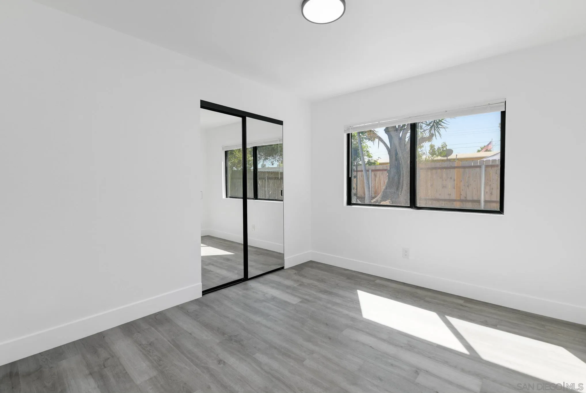 9125 Akard Street Spring Valley, CA 91977 - Photo 19 of 25 an empty room with wooden floor and windows