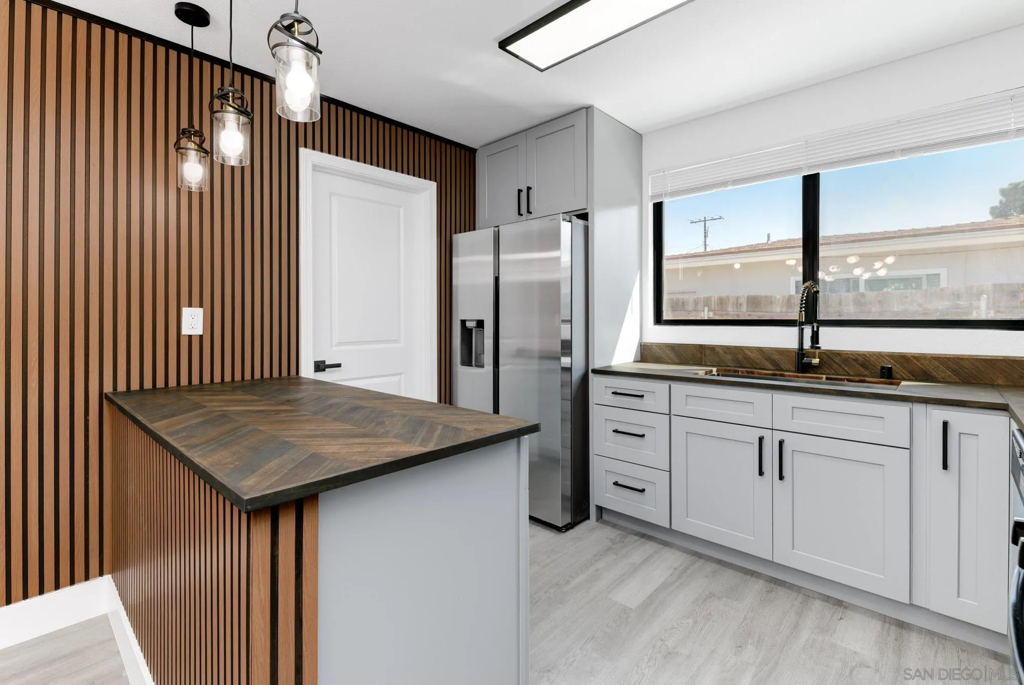 9125 Akard Street Spring Valley, CA 91977 - Photo 5 of 25 a kitchen with stainless steel appliances granite countertop a refrigerator a sink and white cabinets