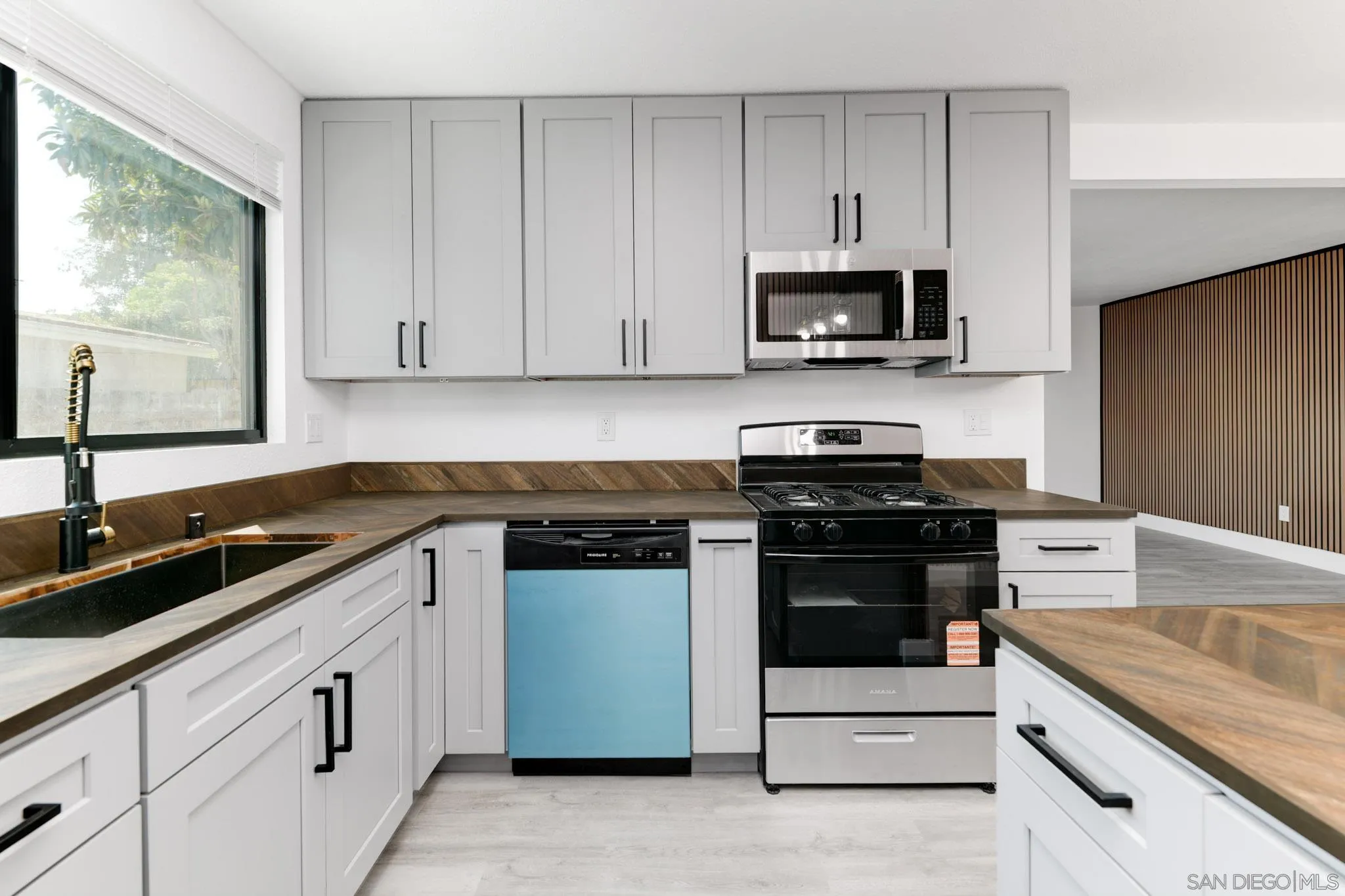9125 Akard Street Spring Valley, CA 91977 - Photo 7 of 25 a kitchen with granite countertop white cabinets and black stainless steel appliances