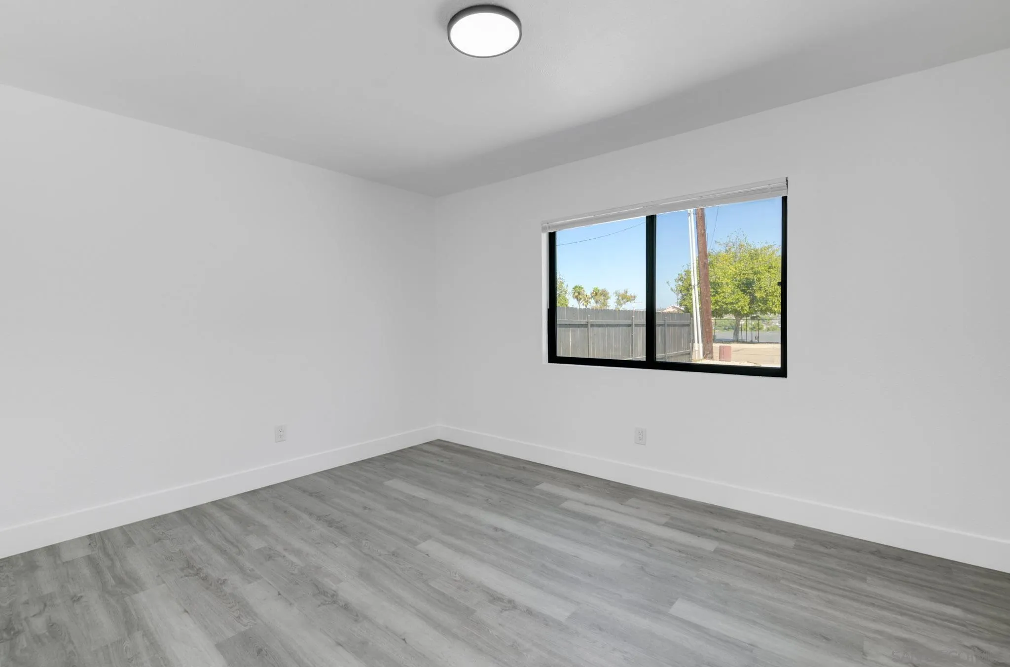 9125 Akard Street Spring Valley, CA 91977 - Photo 9 of 25 an empty room with wooden floor and windows
