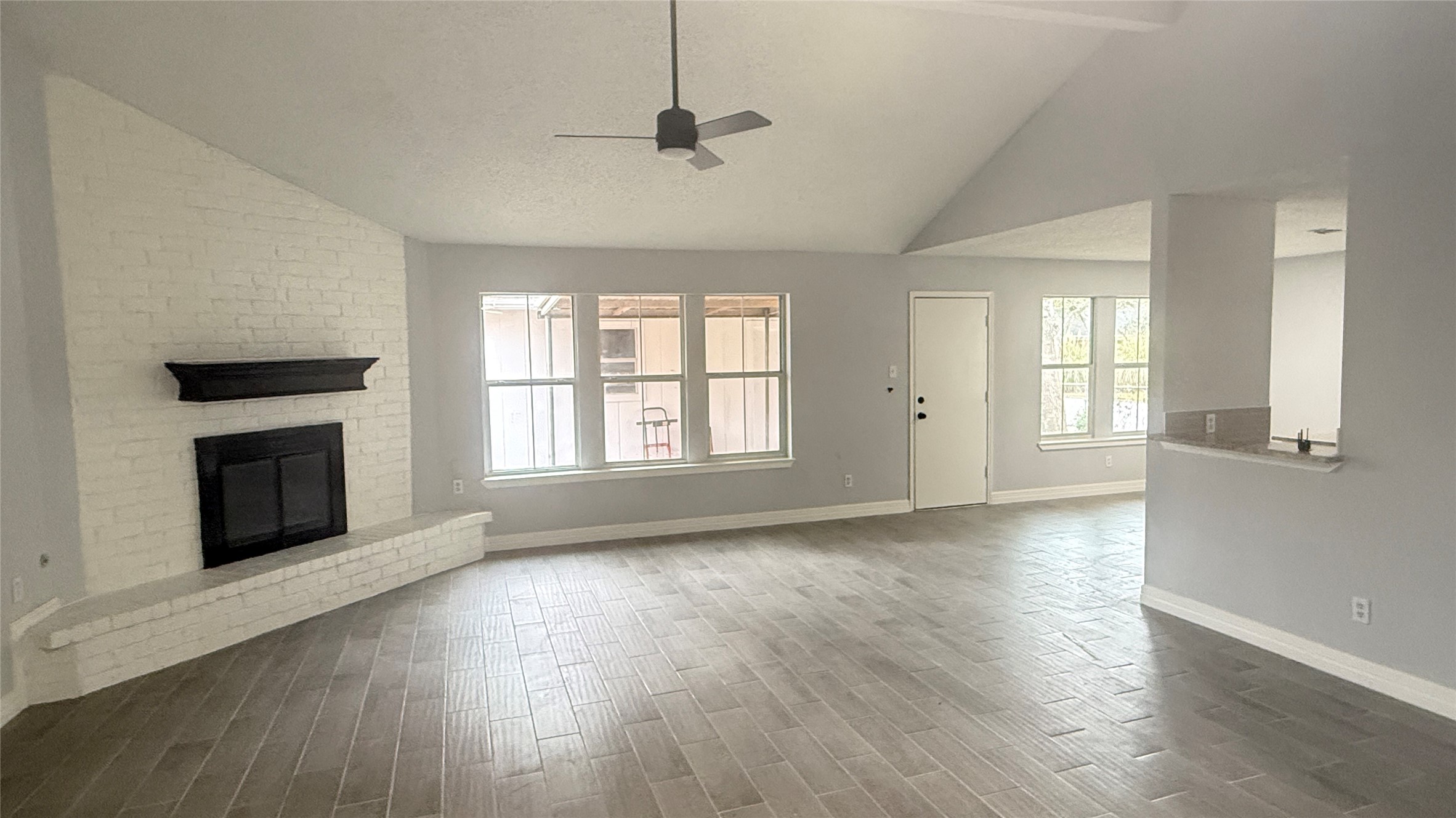4202 Junker Street Rosenberg, TX 77471 - Photo 5 of 20 an empty room with wooden floor fireplace and windows