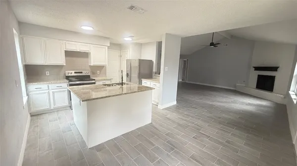 a kitchen with a refrigerator and a stove top oven