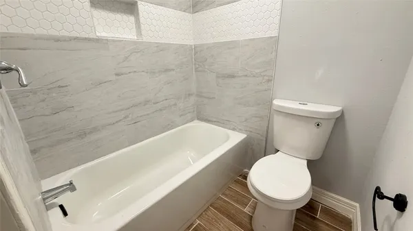 a white toilet sitting next to a bath tub