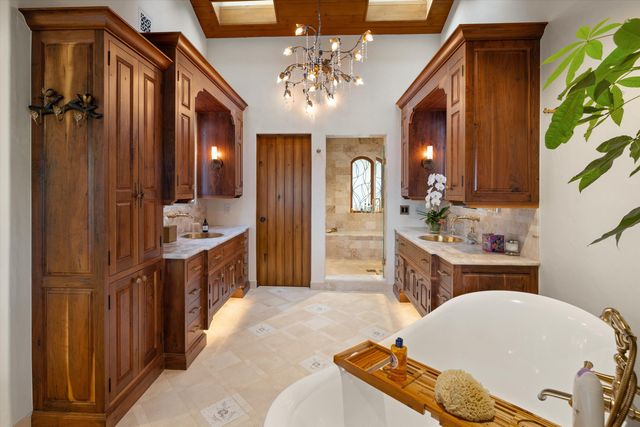 a spacious bathroom with a double vanity sink a mirror a vanity and a bathtub