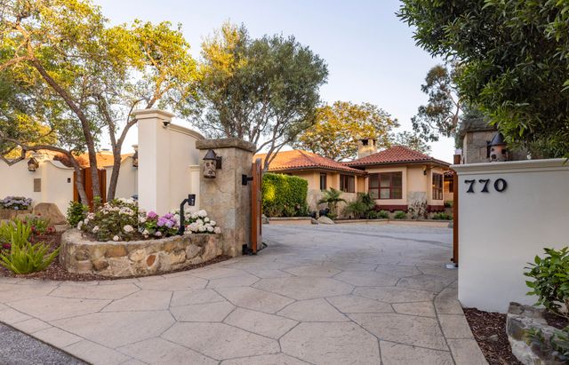 a front view of a house with a garden and plants