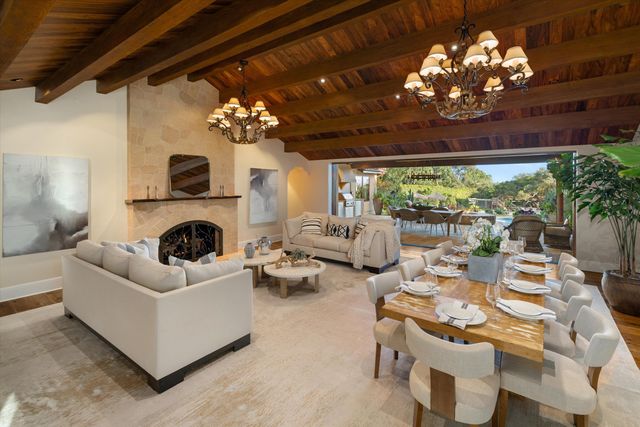 a living room with furniture a chandelier and a fireplace