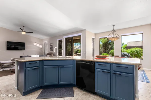 a kitchen with kitchen island granite countertop a sink stainless steel appliances and cabinets