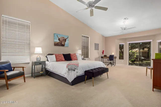 a spacious bedroom with a bed and a chandelier