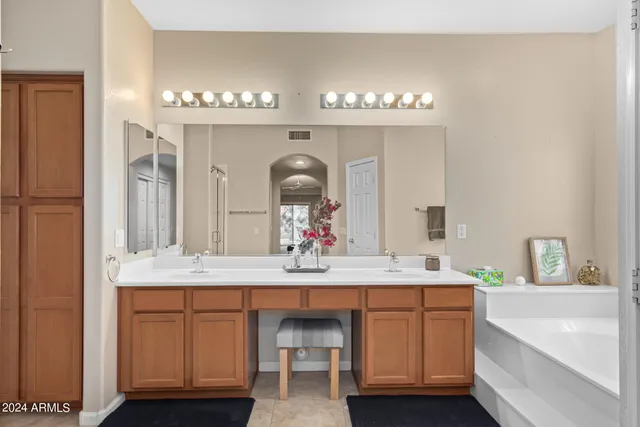 a bathroom with a sink a large mirror and a bathtub