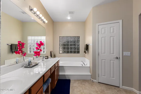 a bathroom with a tub sink and mirror