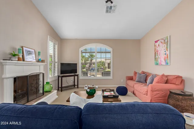 a living room with furniture a fireplace and a large window