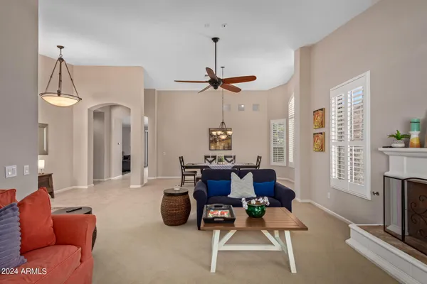 a living room with furniture a fireplace and a chandelier
