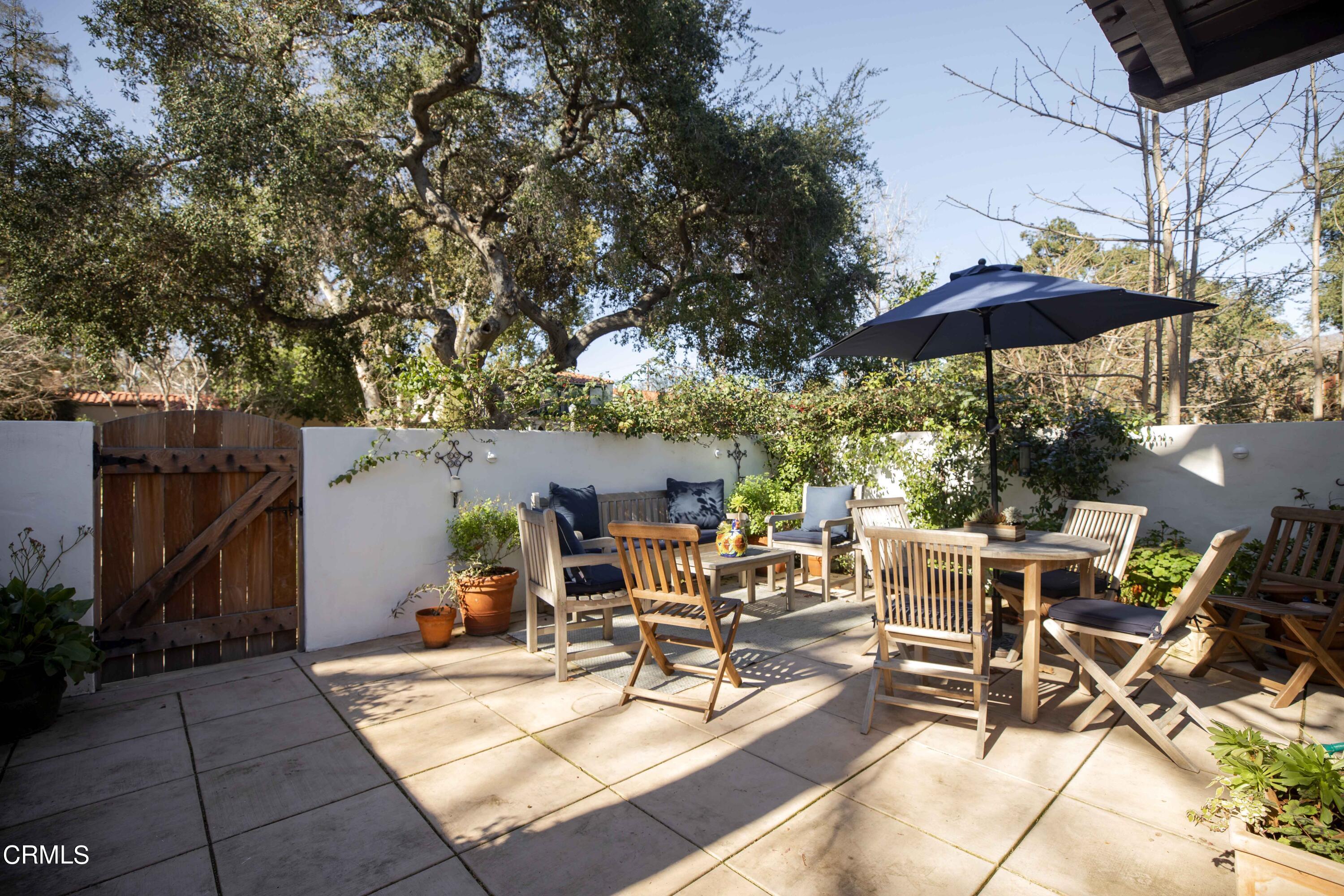 426 South Berkeley Avenue Pasadena, CA 91107 - Photo 3 of 32 a view of a patio with a dining table and chairs under an umbrella with a barbeque